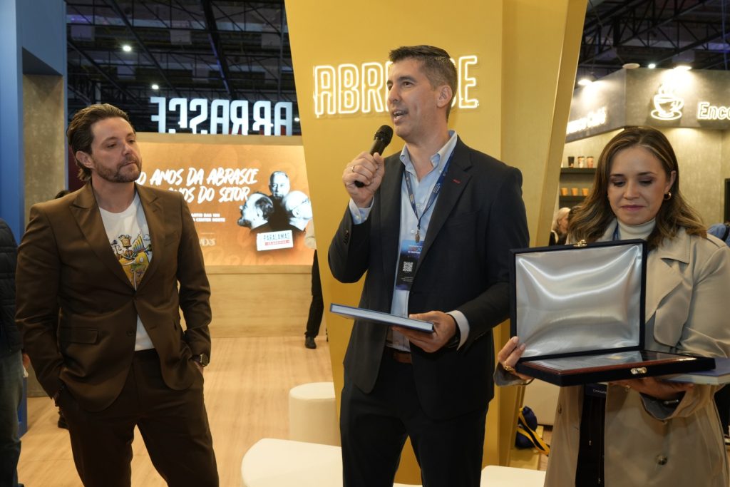 Durante o lançamento, Carlos Hernán Betancourt, diretor executivo da Acecolombia, entrega ao presidente da Abrasce, Glauco Humai, homenagem da Cámara Latinoamericana de la Industria de Centros Comerciales (CLICC)